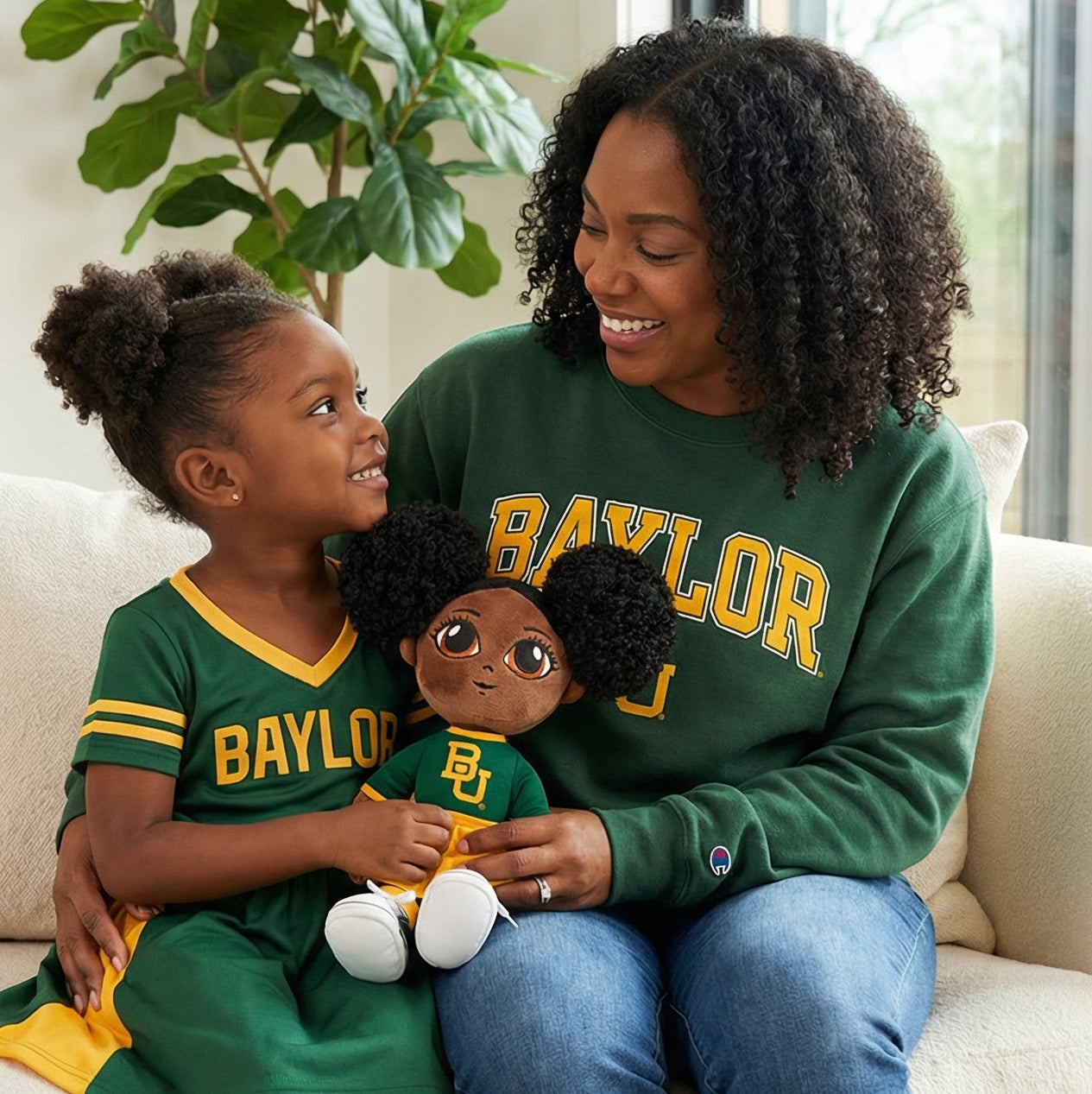 Woman and child sitting on a couch wearing Baylor University clothing in a home setting.