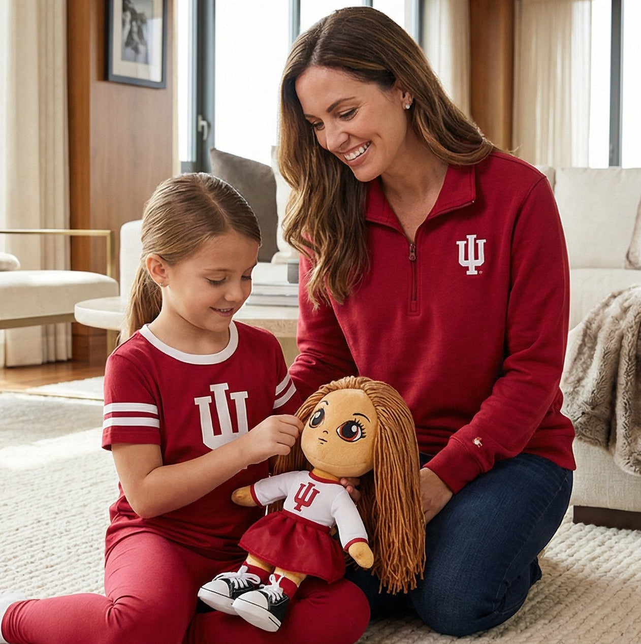 Woman and child in red shirts with a plush toy in a living room.