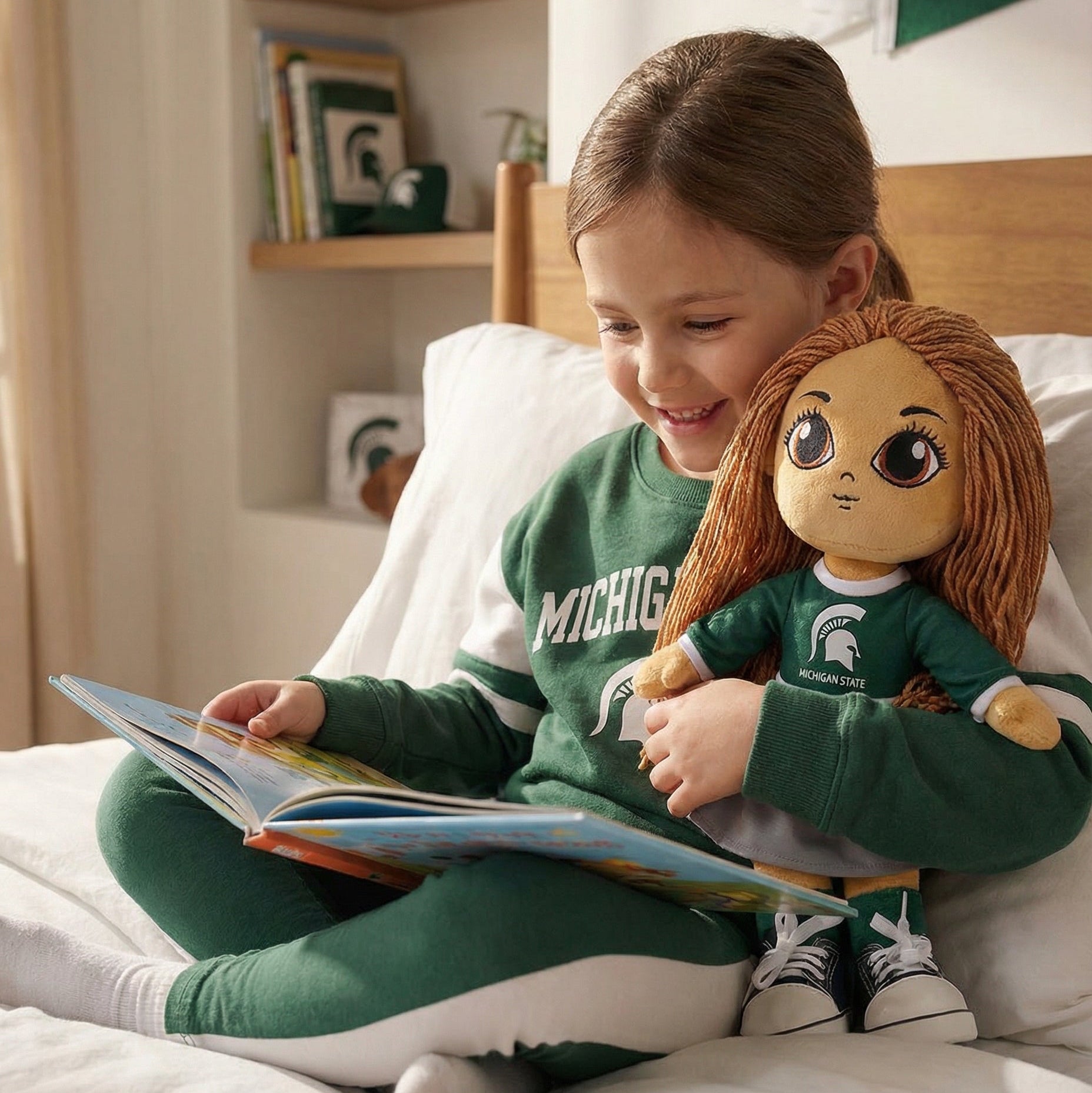 Child reading a book to a doll wearing a Michigan State University shirt in a cozy room.