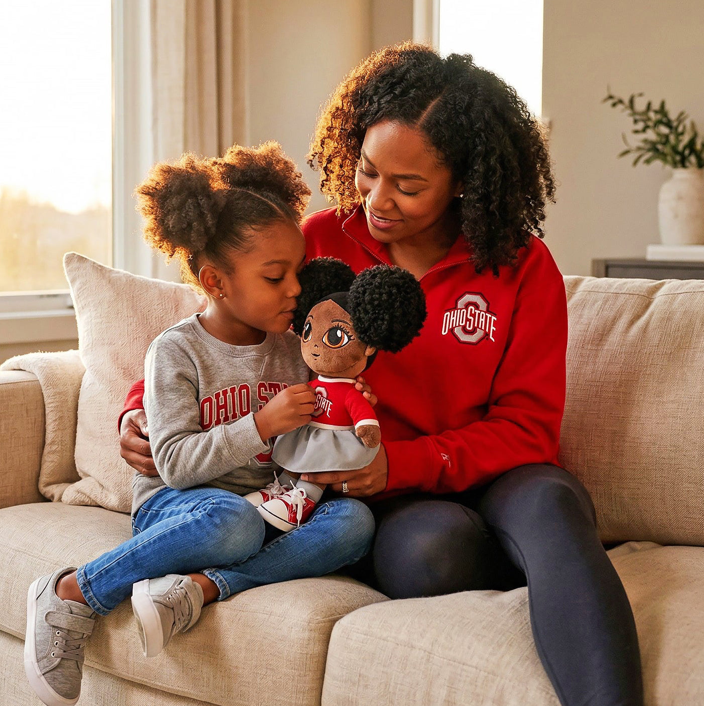 Woman and child sitting on a couch holding a doll in a cozy living room.